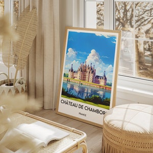 May include: A framed poster with a vintage travel illustration of Ch&acirc;teau de Chambord, a large French castle with a moat and reflection in the water. The poster has the text "Ch&acirc;teau de Chambord, France".