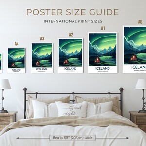 May include: A guide to international poster sizes, showing the different sizes of posters from A5 to A0. The posters feature a green and blue image of a cabin in Iceland with the Northern Lights in the sky. The text "ICELAND" and "AURORA BOREALIS" is printed on each poster. The posters are displayed on a wall above a bed with a headboard and two nightstands.