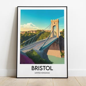 Peut inclure: Impression d'art encadrée représentant le pont suspendu de Clifton à Bristol, Royaume-Uni. L'illustration stylisée montre le pont sous un ciel bleu, avec la ville et la verdure environnante. Le mot "BRISTOL" est imprimé en dessous.