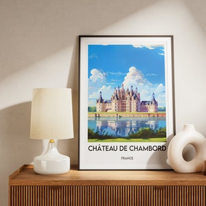May include: A framed print of a painting depicting Ch&acirc;teau de Chambord, a large French castle with a moat and reflecting water. The text below the image reads "Ch&acirc;teau de Chambord, France".