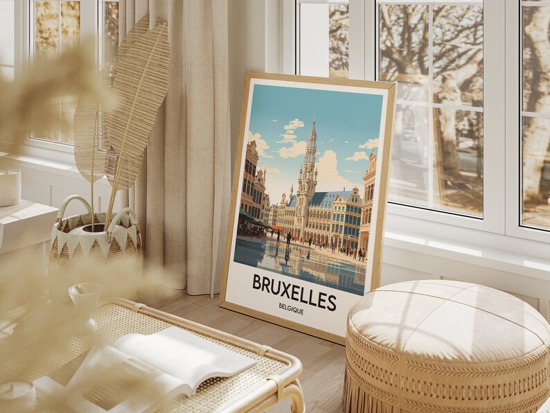 May include: A framed poster with a vintage illustration of the Grand Place in Brussels, Belgium. The poster has a white background with a blue sky and clouds. The text "BRUXELLES BELGIQUE" is printed at the bottom of the poster.