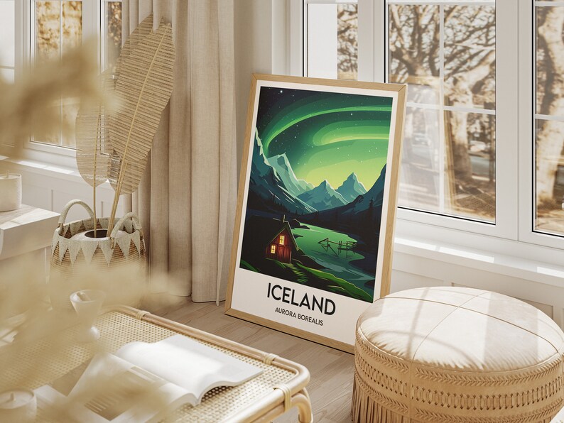 May include: A framed poster with a green and blue illustration of a mountain range with a small cabin in the foreground. The poster has the text "Iceland" and "Aurora Borealis" printed on it.