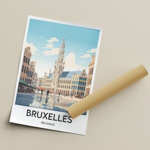 May include: A colorful illustration of the Grand Place in Brussels, Belgium. The image features the iconic Town Hall and surrounding buildings, with a blue sky and white clouds in the background. The text "BRUXELLES BELGIQUE" is printed at the bottom of the image.