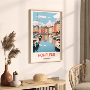 May include: A colourful illustration of the harbour in Honfleur, France. The image features a row of colourful buildings along the waterfront, with boats docked in the harbour. The text "Honfleur, Normandie" is printed below the image.