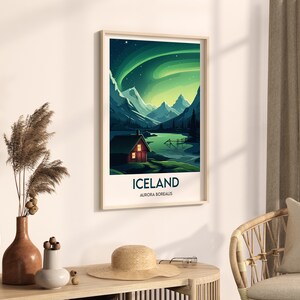 May include: A framed poster with a green and blue aurora borealis scene over a mountain range and a small red cabin. The poster has the text "Iceland, Aurora Borealis" at the bottom.