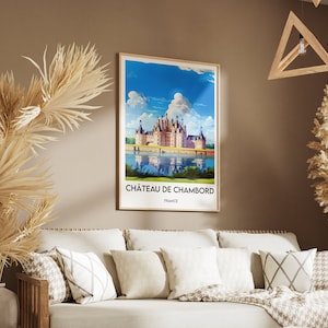 May include: A framed poster with a vintage travel illustration of Ch&acirc;teau de Chambord, a large French castle with a moat, surrounded by trees and a blue sky with white clouds. The text on the poster reads "Ch&acirc;teau de Chambord, France".