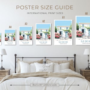 Op de afbeelding: Een gids voor posterformaten met een wit huis met een blauwe deur en een fiets ervoor. De posterformaten zijn A0, A1, A2, A3, A4 en A5. De poster hangt aan een muur boven een bed met een wit hoofdeinde en een wit dekbed. Het bed is 80 inch (203 cm) breed.