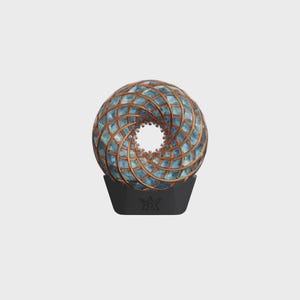 May include: A decorative sphere with a spiral design, featuring a combination of blue and copper-colored elements. The sphere sits atop a black base with a star-like emblem, creating a modern, artistic sculpture.