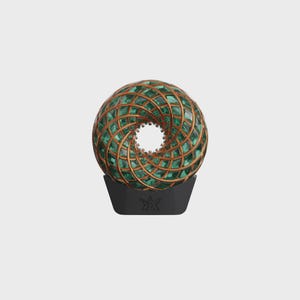 Könnte beinhalten: Eine dekorative Kugel mit geometrischem Design, die ein Netzwerk aus goldfarbenen Linien und grünen, edelsteinartigen Einsätzen aufweist. Die Kugel steht auf einem schwarzen Sockel mit einem stilisierten Emblem. Das Design hat ein Spiralmuster.