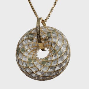 May include: A gold-toned necklace featuring a pendant with a spiral design. The pendant is a sphere made of clear and green glass pieces, encased in a gold-colored metal frame. The word "iPYRAMID" is engraved on the pendant's loop.