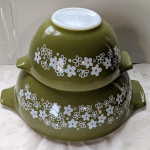 May include: A set of three ceramic mugs with a speckled, matte finish. The mugs are in shades of cream, light gray, and dark gray. Each mug has a simple, minimalist design and a rounded handle.