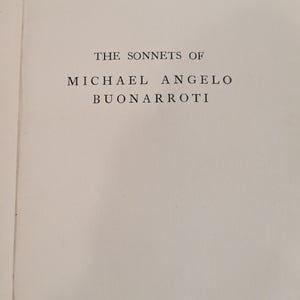 May include: A book page with off-white paper featuring centered black serif text that reads THE SONNETS OF MICHAEL ANGELO BUONARROTI. The text is arranged in three lines with the first line in smaller font and the following two lines larger.