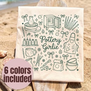 May include: A beige tote bag with a green illustration of pottery tools and the text "Pottery Girlie." The design includes a pottery wheel, kiln, brushes, and an apron. A pink circle with the text "6 colors included" is in the lower left corner.