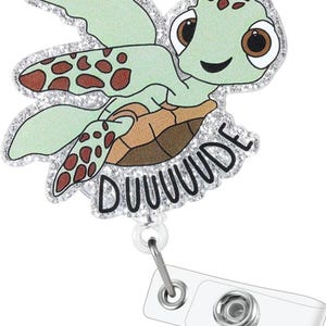 May include: A green and brown glitter turtle with the text "DUUUUUDE" on the bottom. The turtle is attached to a clear plastic retractable badge holder.