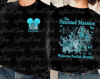 May include: Black sweatshirt with a blue Mickey Mouse head and the text "The Haunted Mansion" with a blue ghost image and the text "Welcome Foolish Mortals".