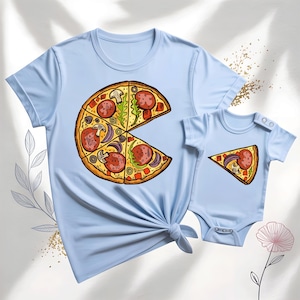 May include: Light blue t-shirt and baby onesie set. The t-shirt features a large pizza graphic with pepperoni, olives, and onions. The onesie has a matching pizza slice design. A fun, matching outfit for parent and child.