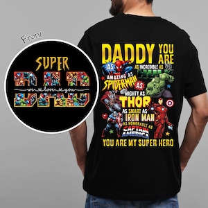 Puede incluir: Camiseta negra con un gráfico que presenta el texto "DADDY YOU ARE" y personajes de superhéroes como Spider-Man, Hulk, Thor, Iron Man y Capitán América. La parte delantera de la camiseta tiene las palabras "SUPER DAD" y "we love you".