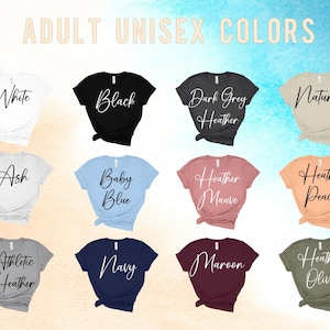 Puede incluir: Una selecci&oacute;n de camisetas unisex en varios colores, incluyendo blanco, negro, gris oscuro jaspeado, natural, ceniza, azul beb&eacute;, malva jaspeado, melocot&oacute;n jaspeado, gris jaspeado atl&eacute;tico, azul marino, granate y oliva jaspeado. Las camisetas se muestran sobre un fondo marr&oacute;n claro.