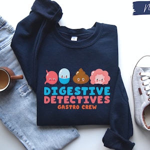 May include: Navy blue sweatshirt with a graphic of cartoon digestive system organs and the text "Digestive Detectives Gastro Crew".