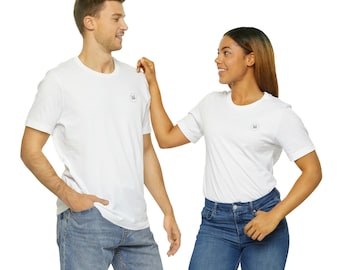 May include: Two people wearing white t-shirts with a small logo on the front. The man is wearing blue jeans and the woman is wearing blue jeans. They are looking at each other and smiling.