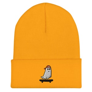 May include: A yellow beanie with a white ghost wearing a red hat and skateboarding embroidered on the front.