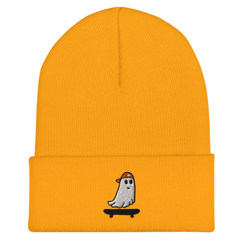 May include: A yellow beanie with a white ghost wearing a red hat and skateboarding embroidered on the front.