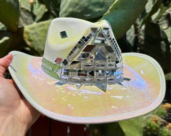 May include: A white cowboy hat with a iridescent finish and a mirrored mosaic design on the crown.
