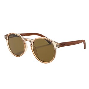 May include: Round sunglasses with a clear, light brown frame and dark brown lenses. The temples are made of dark wood and feature the brand name. These sunglasses offer a stylish and classic look.