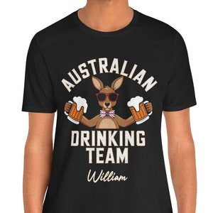 Pode incluir: Camiseta preta com um canguru usando óculos de sol e gravata borboleta segurando duas cervejas. O texto na camiseta diz "Australian Drinking Team William".