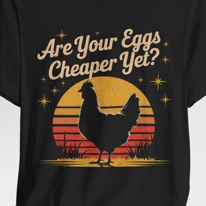 T-Shirt. Chicken silhouetted against a vintage sunset with text "Are Your Eggs Cheaper Yet?"
