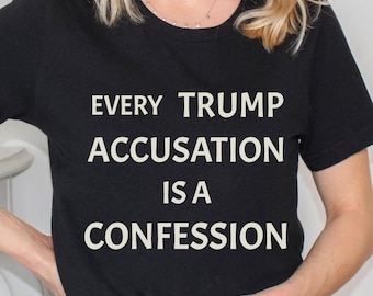 Puede incluir: Camiseta negra con el texto blanco "EVERY TRUMP ACCUSATION IS A CONFESSION". La camiseta de cuello redondo está hecha de un material suave. El texto está centrado en la parte delantera de la prenda.