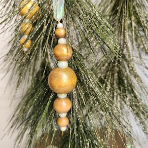 Set of 6 wooden beaded ornaments, decorated with soft blue color glass beads.