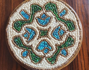 Wooden Teapot Coaster decorated with glass beads in turquoise, green, beige, and copper colors.