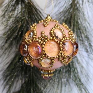 Christmas ornament decorated with pink and golden glass beads.