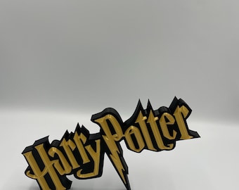 May include: A three-dimensional sign featuring the text Harry Potter in a stylized font. The lettering is gold with a thick black border and a black base, creating a layered effect. The letter P features a lightning bolt design extending downward.