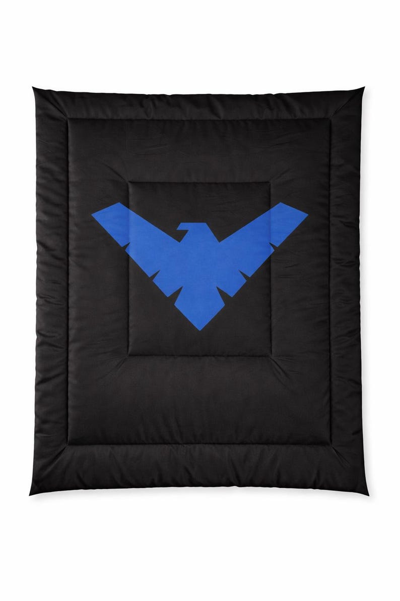 Może przedstawiać: Czarna kołdra z dużym niebieskim emblematem ptaka. Emblemat jest wyśrodkowany na kołdrze, kt&oacute;ra ma pikowany wz&oacute;r. Kołdra jest w jednolitym czarnym kolorze.