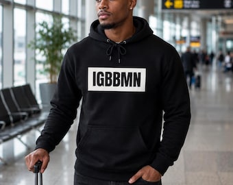 May include: A black hooded sweatshirt featuring a white rectangular graphic on the chest with the black text IGBBMN printed inside. The garment includes a drawstring hood, long sleeves with ribbed cuffs, and a front kangaroo pocket for storage.