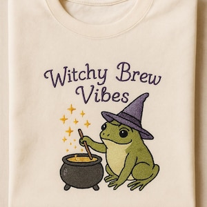 Witchy Brew Vibes Embroidered Sweatshirt – Frog with Cauldron and Hat Cream Pullover