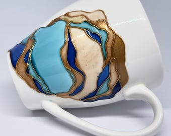 Taza de café abstracta con diseño marino pintado a mano: Arte oceánico dorado y azul