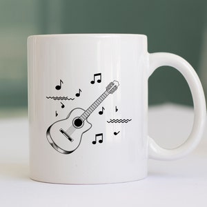 May include: White ceramic mug with a black and white illustration of an acoustic guitar and musical notes.