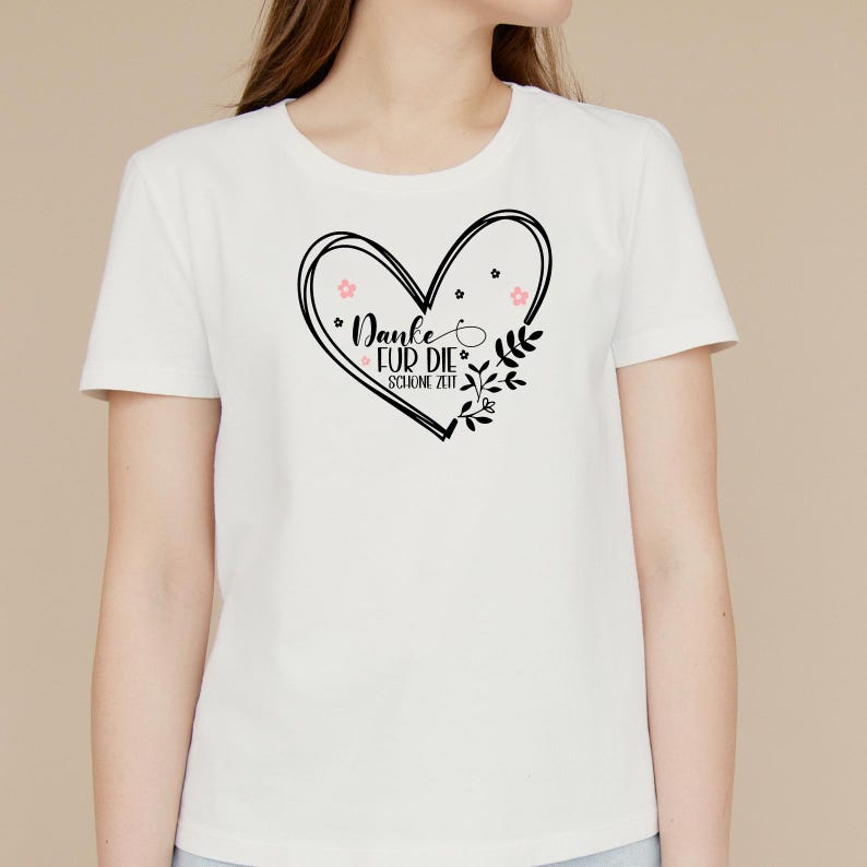 Peut inclure: T-shirt blanc avec un motif de c&oelig;ur noir qui dit "Danke fur die schone Zeit" avec des fleurs roses et des feuilles.