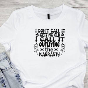 May include: White t-shirt with black text that reads "I don't call it getting old I call it outliving the warranty".