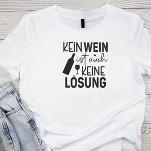 Op de afbeelding: Wit T-shirt met zwarte tekst die "Kein Wein ist auch keine L&ouml;sung" luidt.