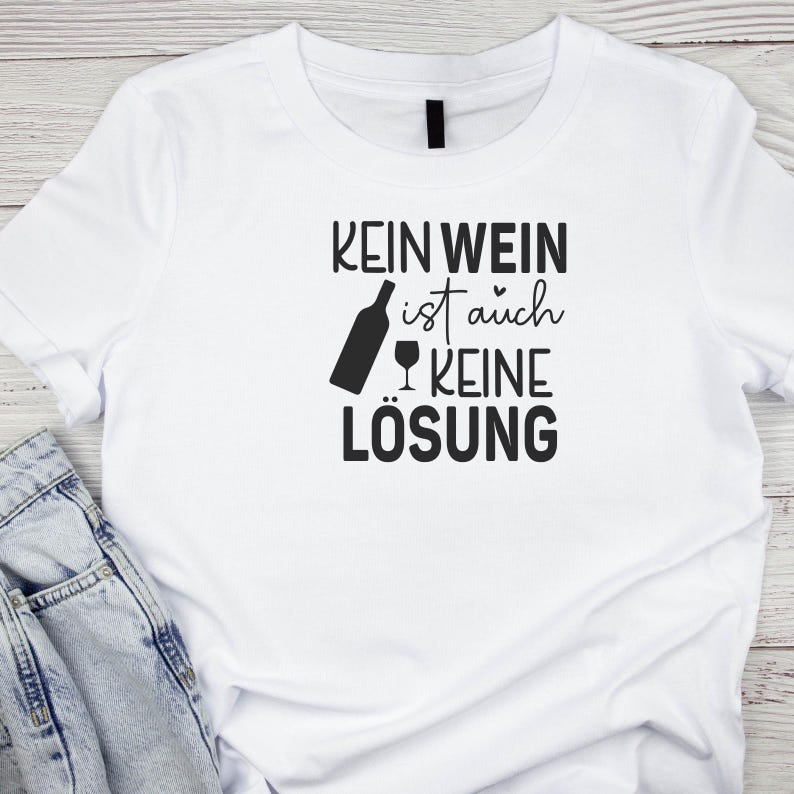 Op de afbeelding: Wit T-shirt met zwarte tekst die "Kein Wein ist auch keine L&ouml;sung" luidt.