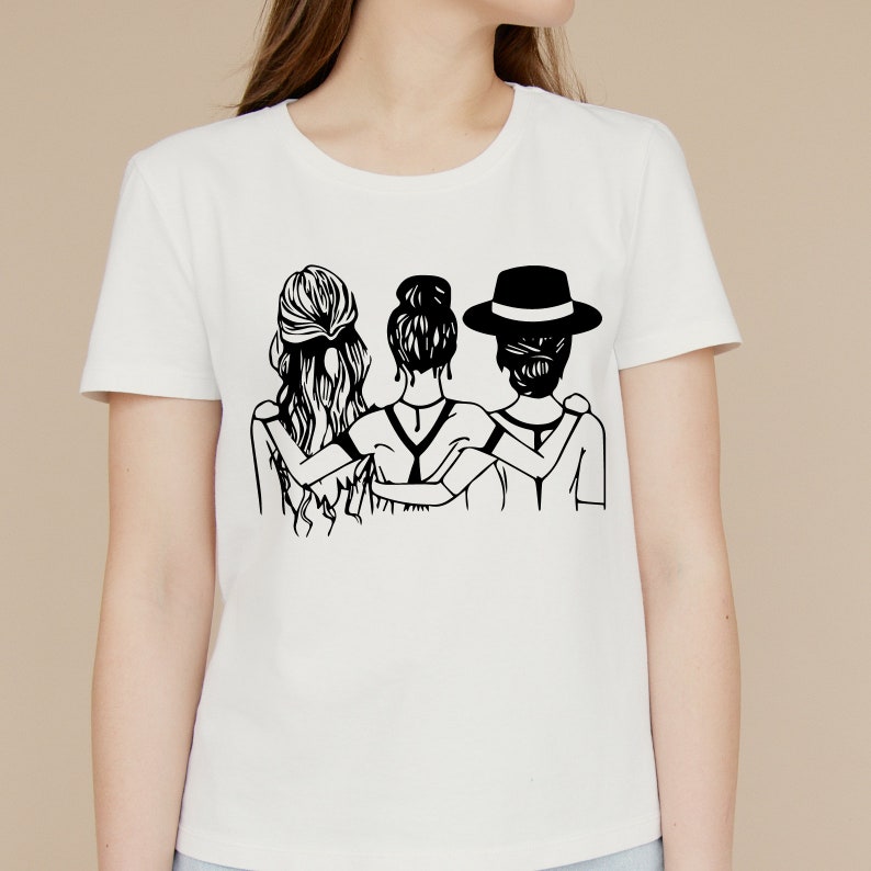 May include: A white t-shirt with a black graphic of three women standing back to back with their arms around each other. The woman in the middle has her hair pulled back in a bun. The woman on the left has long, flowing hair. The woman on the right is wearing a hat.