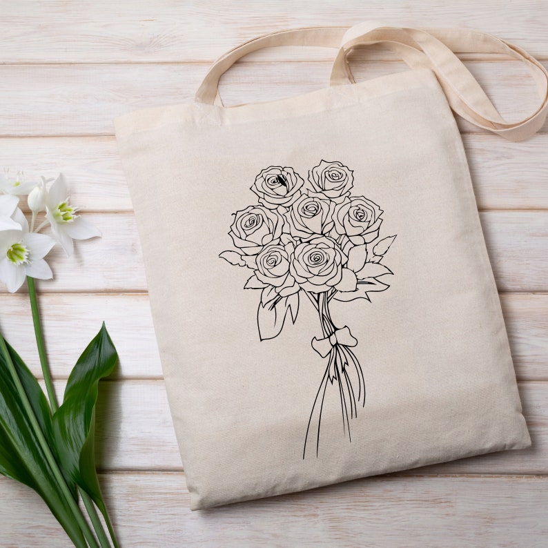 May include: A white canvas tote bag with a black line drawing of a bouquet of roses.