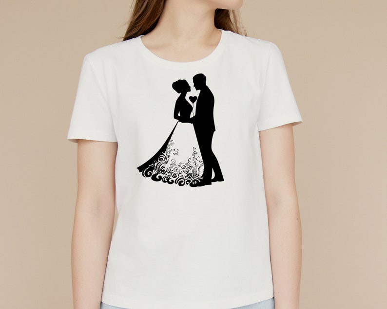 May include: White t-shirt with a black silhouette of a bride and groom embracing.