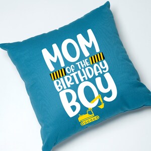 May include: Blue throw pillow with white text that reads "Mom of the Birthday Boy" with a yellow and black striped design and a yellow excavator graphic.