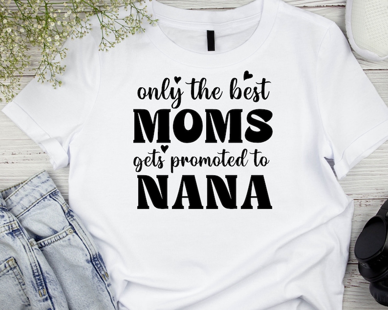 May include: White t-shirt with black text that reads "only the best moms gets promoted to nana".