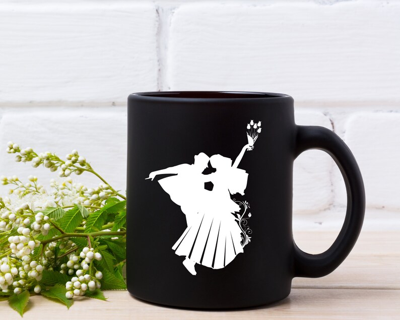 May include: Black ceramic mug with a white silhouette of a couple dancing. The woman is holding a bouquet of flowers.